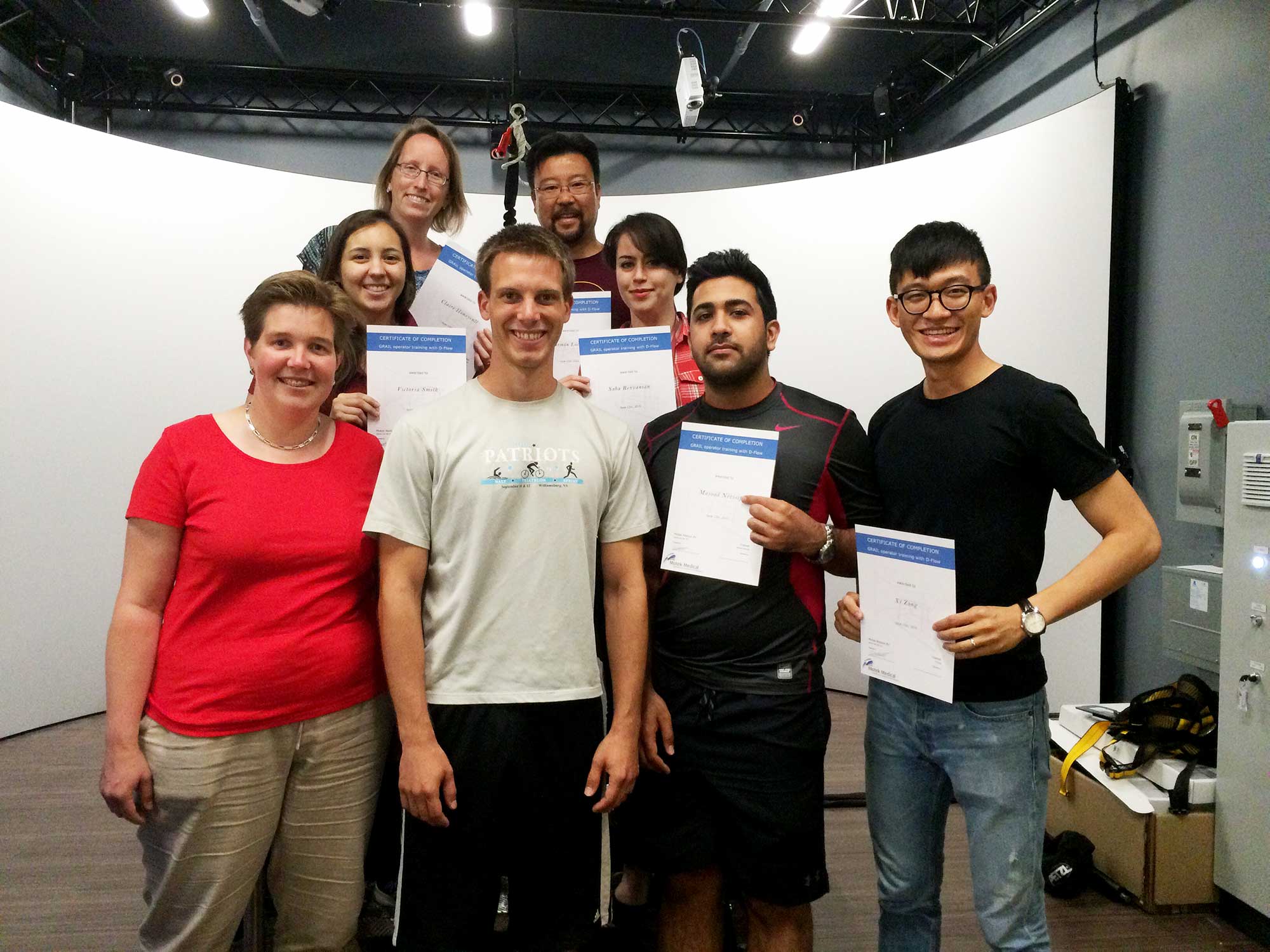 A group of people are shown holding their GRAIL training certificates