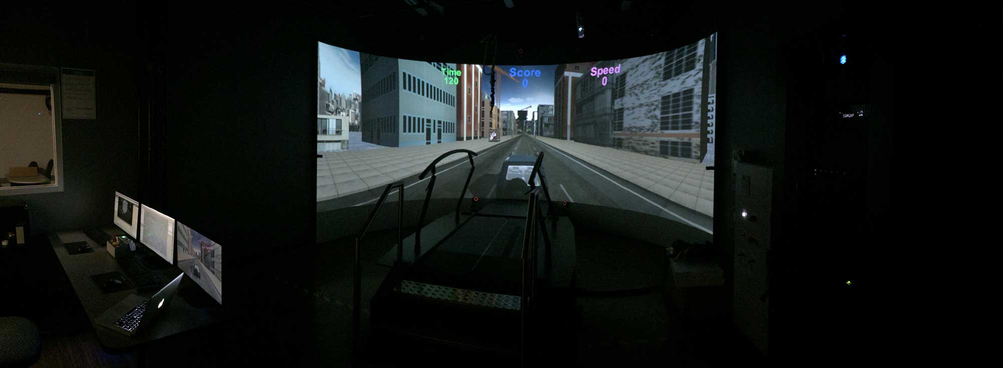 A virtual reality city displays on the enormous curved screen that surrounds the rehab treadmill