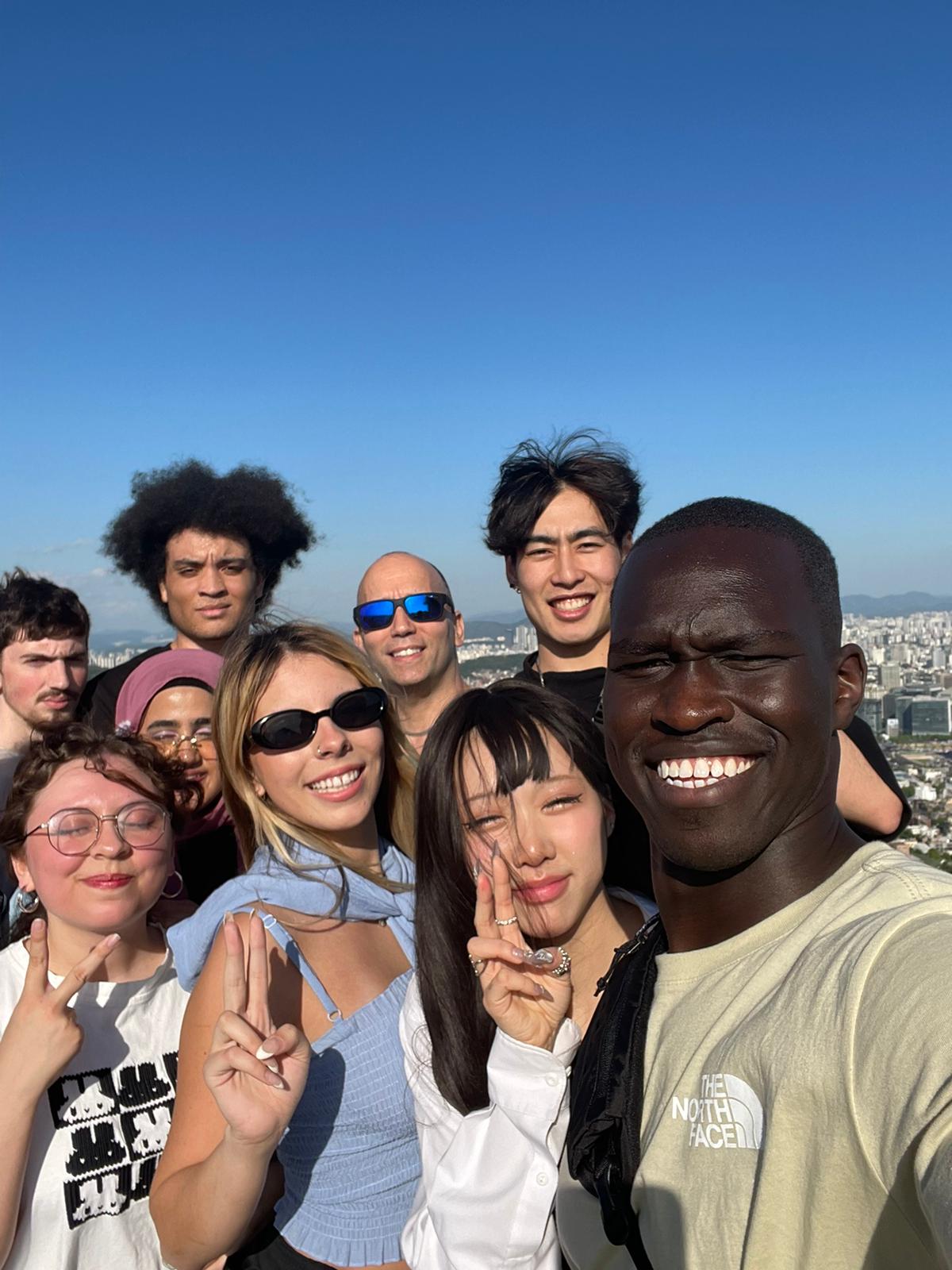 Group of students posting at the top of Inwangsan Mt-Seoul Korea