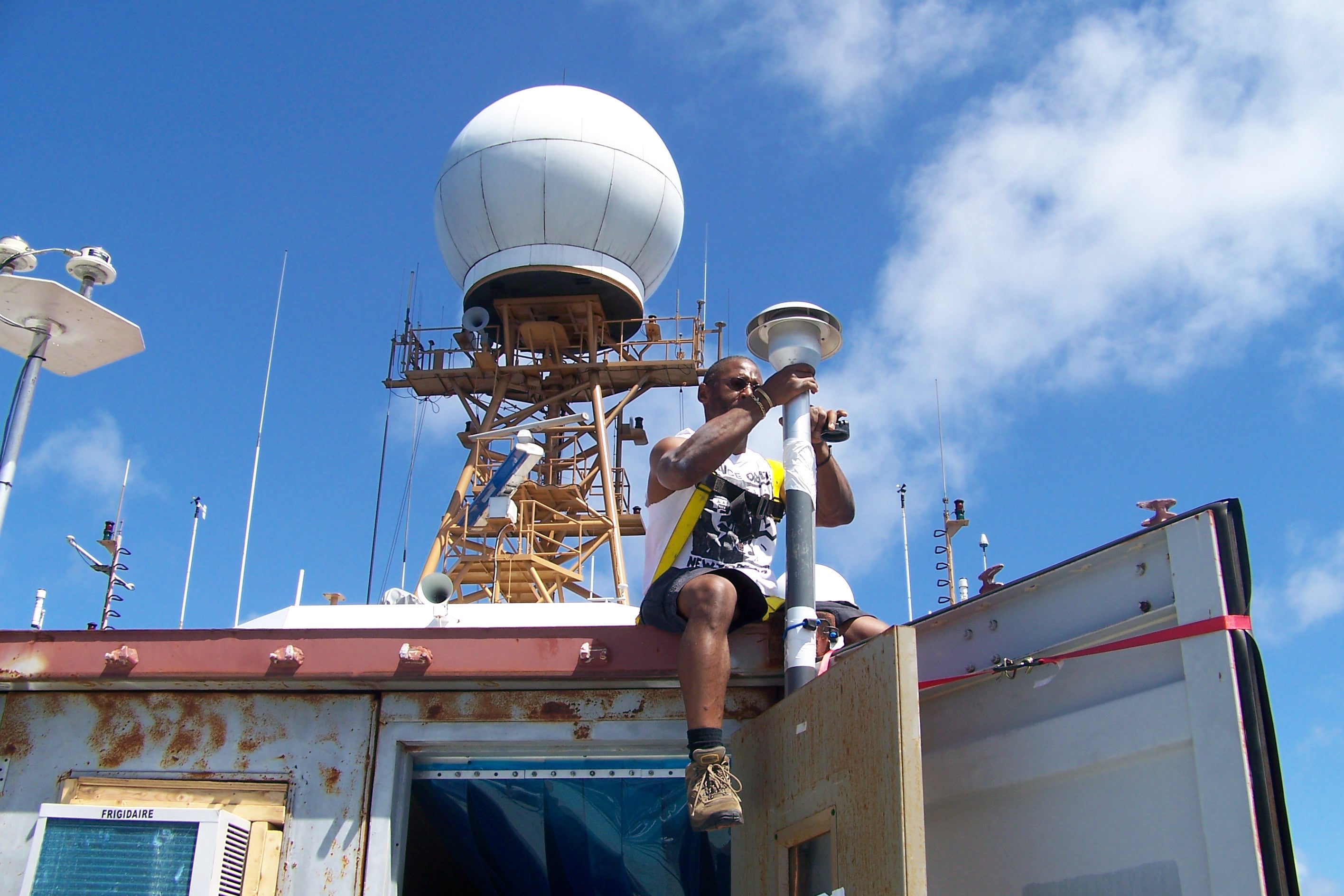 Image of Vernon Morris installing instrumentation on the roof of a mobile lab aboard the NOAA Ronald H. Brown